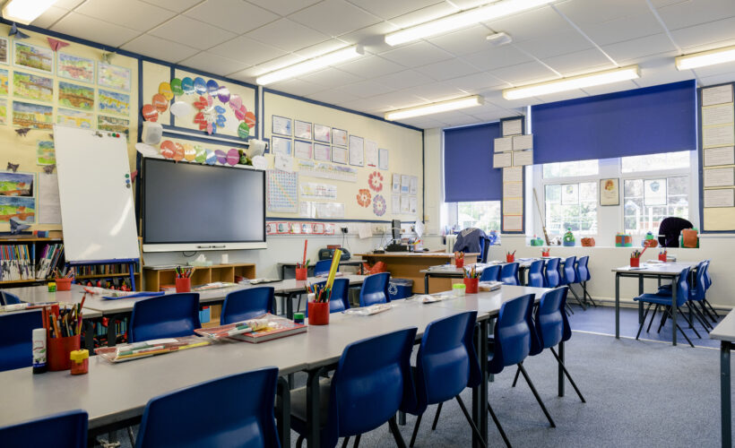 A wide angle view of an organised and tidy classroom in a school