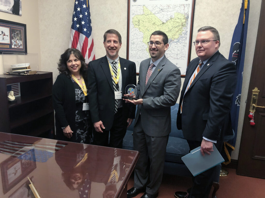 Member Outreach Manager Lena Hannah PSBA President David Hein and PSBA CEO Nathan Mains present Rep. Ortitay with PSBA Champion of Eudcation award